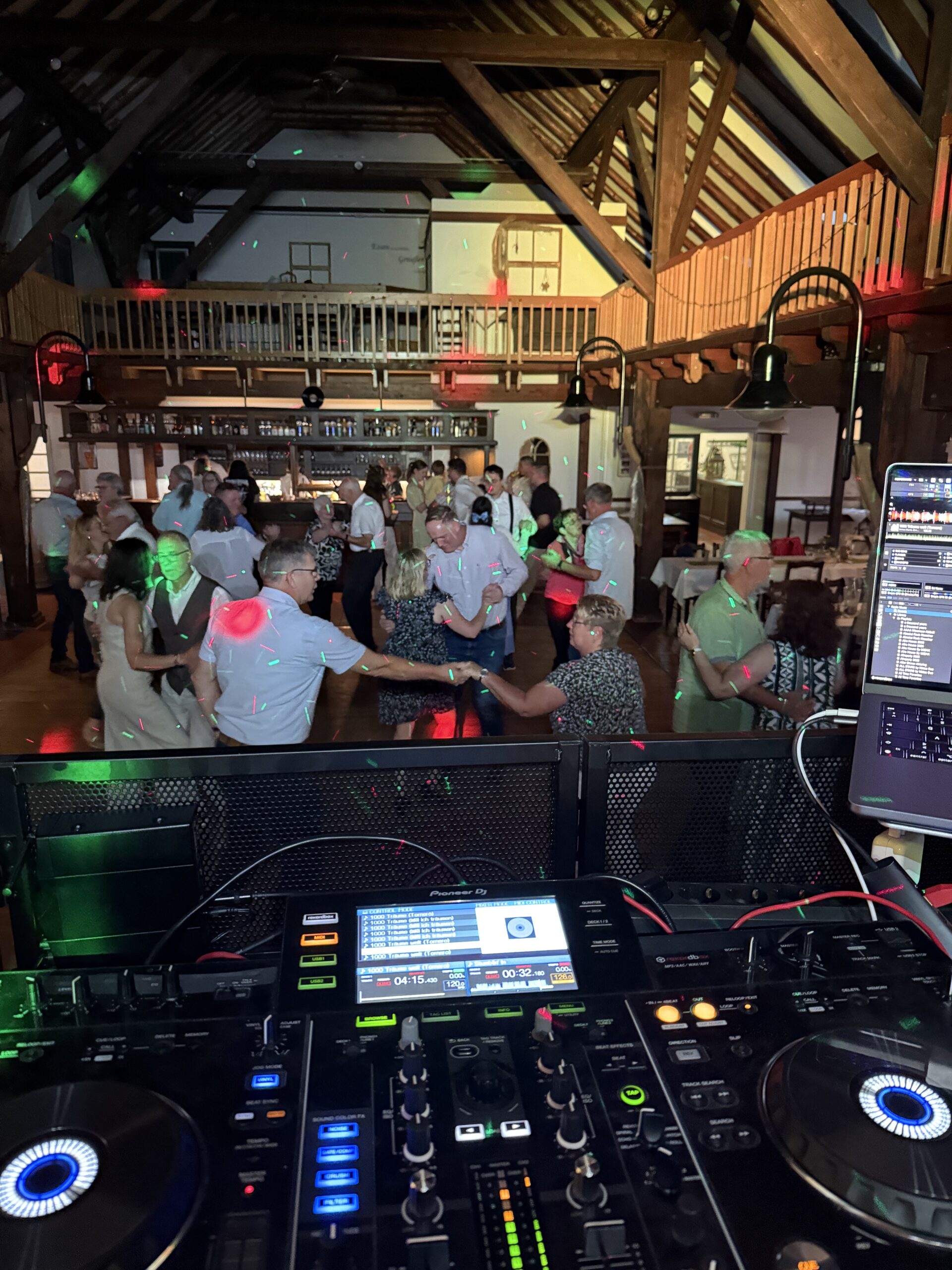 Ältere Menschen tanzen Paartanz auf der Tanzfläche, DJ Pult im Vordergrund