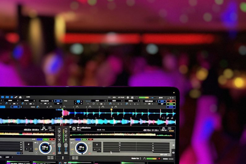 DJ Software Rekordbox mit feiernden Menschen im Hintergrund