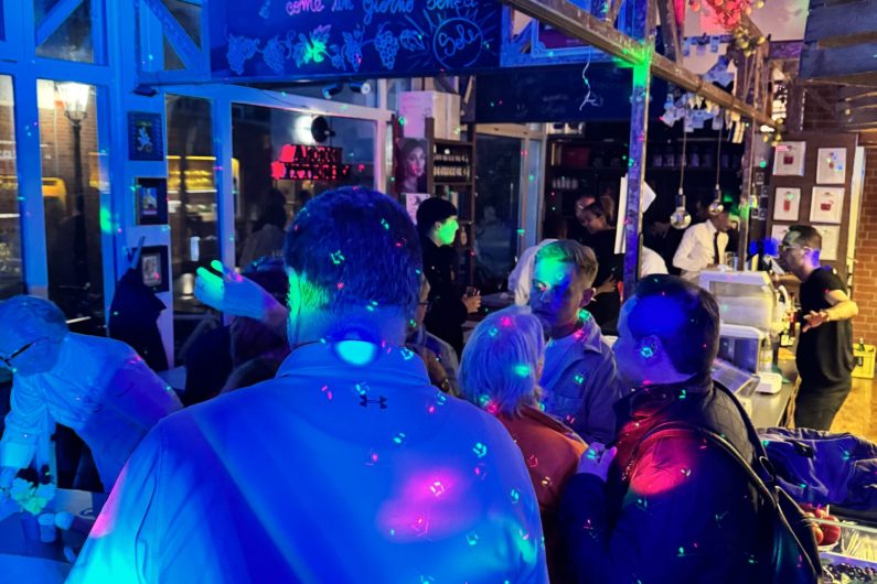 Tanzende Menschen im Schein von buntem Licht