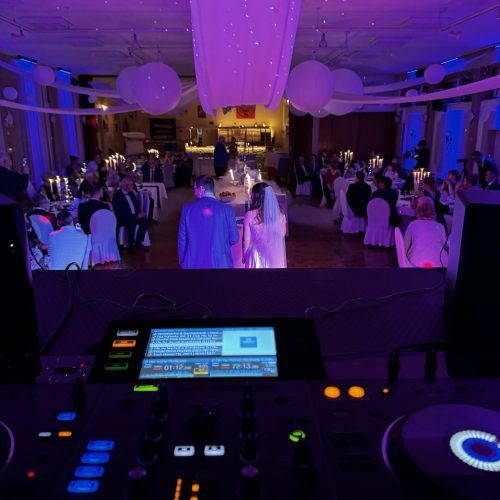 Torte anschneiden auf einer Hochzeit, DJ Pult im Vordergrund