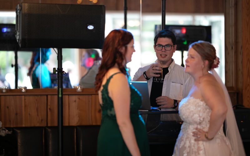 DJ unterhält sich mit Braut und Trauzeugin